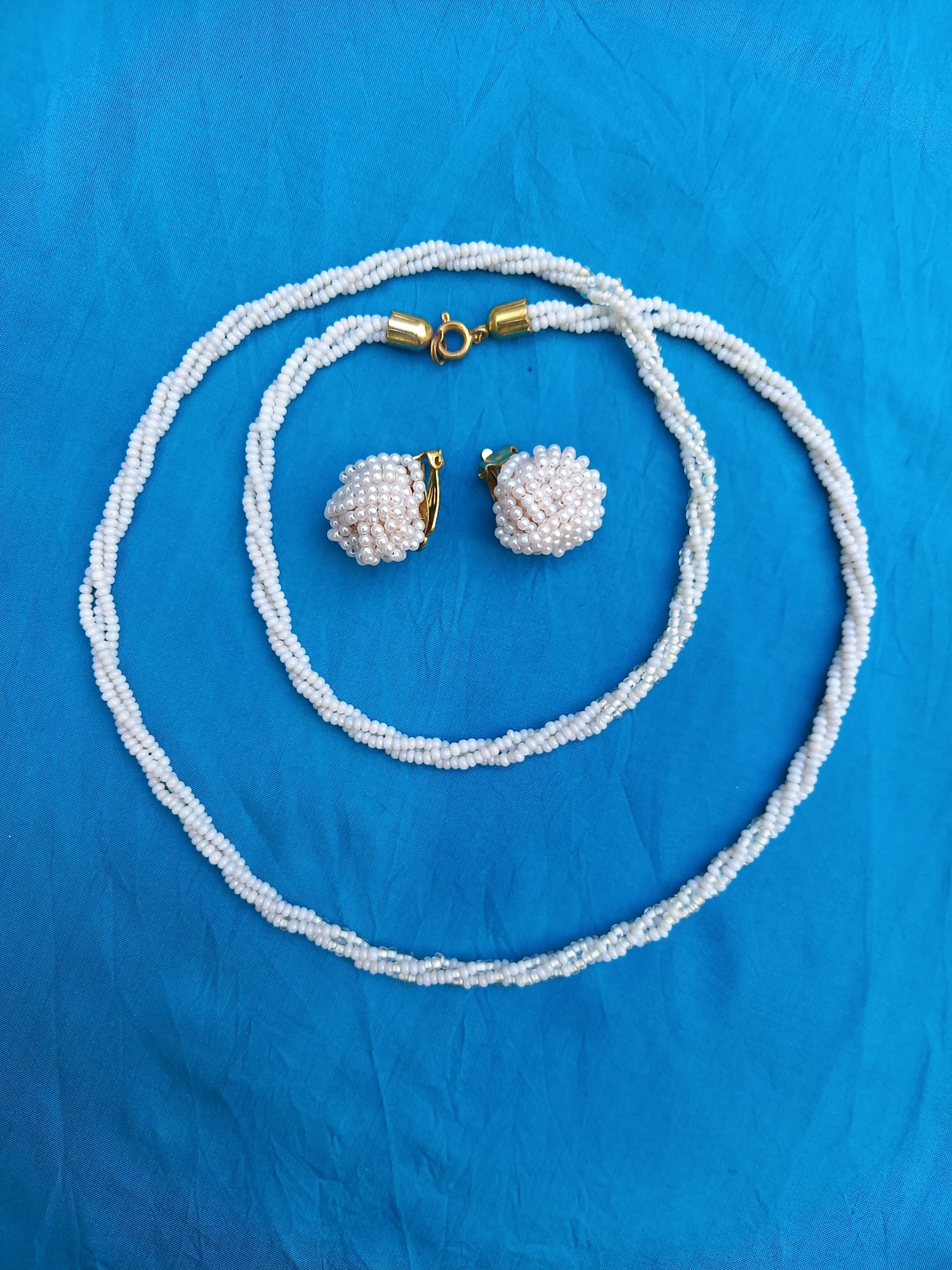fijn wit kettinkje met 2 clips op een blauwe doek